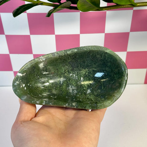 Curvy moss agate bowl, deep green with white inclusions, held in a hand.