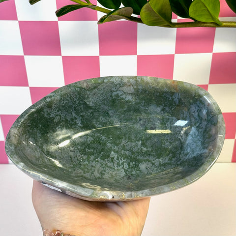 Curvy moss agate bowl with deep green and white patterns, held in a hand.