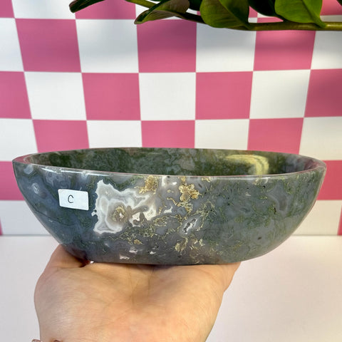 Curvy moss agate bowl, variant C, held in hand, showcasing natural green, white, and brown patterns.