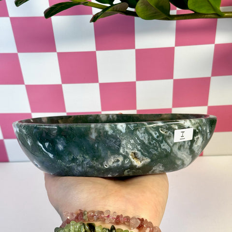 Curvy moss agate bowl, deep green with white veining and natural crystal pockets, held in a hand.