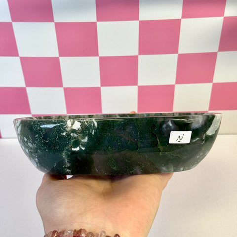 Curvy moss agate bowl, deep green with white inclusions, held in hand.