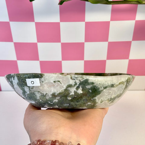 Curvy moss agate bowl with natural green and white patterns, held in a hand.