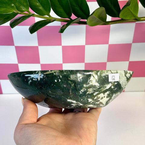 Curvy moss agate bowl, dark green with white marbling, held in hand.