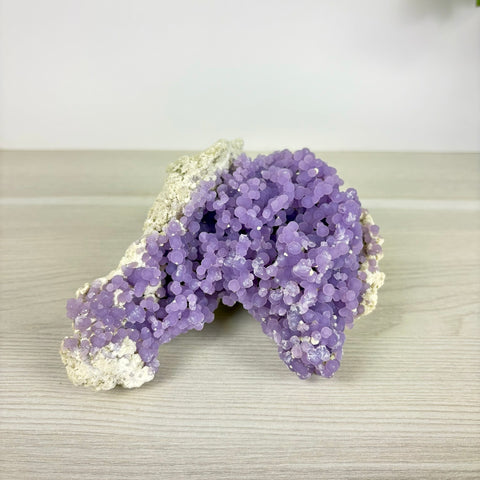 Grape agate specimen featuring vibrant purple botryoidal crystal clusters on a natural white rocky matrix.