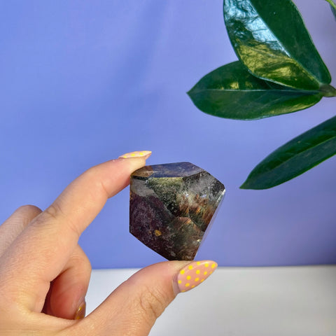Garden Quartz Free Form, a small, multi-faceted crystal with dark green, red, and brown inclusions.