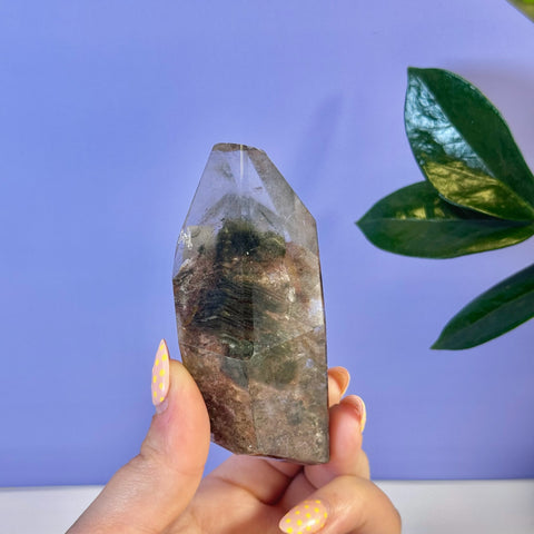 Garden Quartz Free Form with green and brown inclusions, held by a hand with yellow polka dot nails.