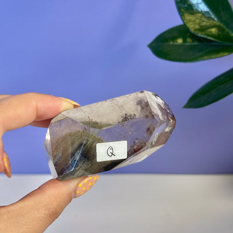 Garden Quartz Free Form, clear crystal with green and purple inclusions, held by hand.