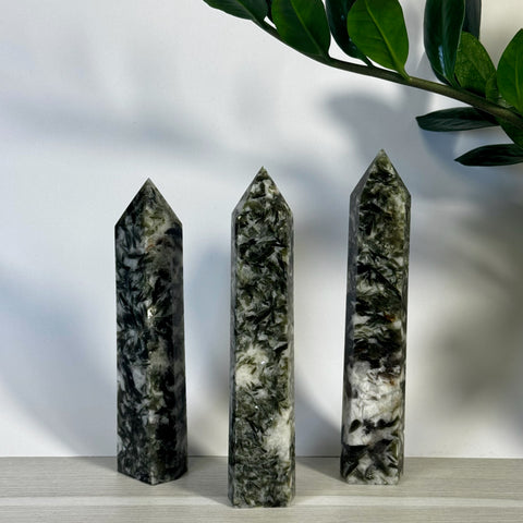 Three imperfect green mica crystal towers with pointed tops, varying in height.