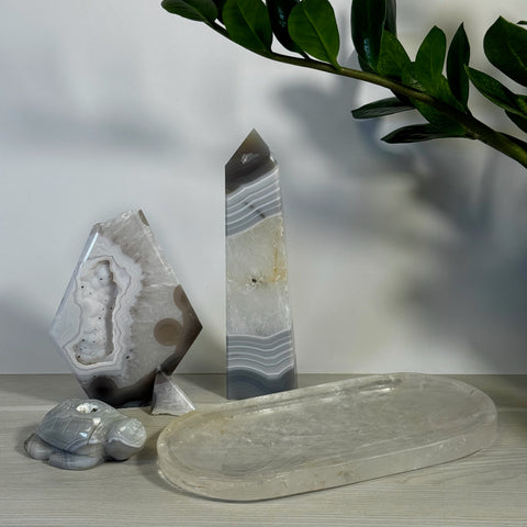 Gray and white agate crystal bundle: geode, obelisk, turtle carving, and clear quartz tray.