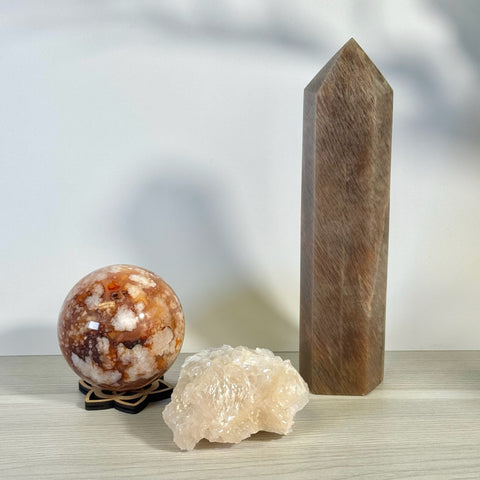Kenna's Stylized Imperfect Bundle: A tall brown crystal tower, a round orange and white crystal sphere on a stand, and a raw white crystal cluster.