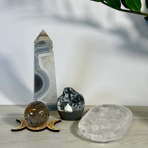Kenna's Stylized Imperfect Bundle B3: Clear quartz sphere on a triple moon stand, tall gray agate tower, dark geode, and clear crystal slab.