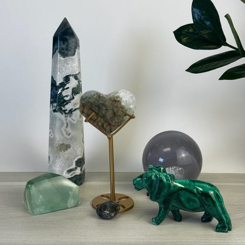 Kenna's Stylized Imperfect Bundle: green malachite lion, tall white and green crystal tower, heart crystal on gold stand, green crystal chunk, and grey crystal sphere.
