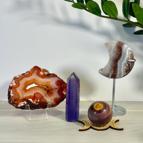 Kenna's Stylized Imperfect Bundle: Agate slice, purple crystal tower, moon-shaped agate, and sphere on a wooden stand.