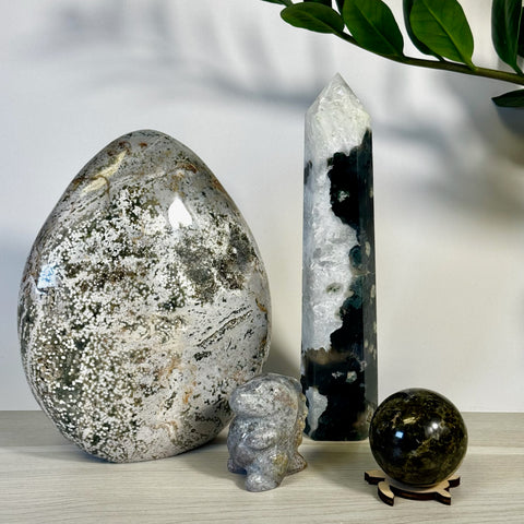 Kenna's Stylized Imperfect Bundle: large speckled crystal egg, tall white and black crystal tower, small crystal owl, and dark green crystal sphere on a stand.
