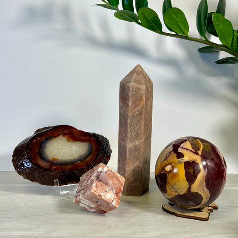 Kenna's Imperfect Bundle G: Brown agate slice, tall peach crystal tower, pink marbled cube, and red/yellow crystal sphere.