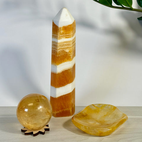 Kenna's Stylized Imperfect Bundle: Orange and white striped crystal tower, clear yellow crystal sphere on wood stand, and yellow crystal dish.