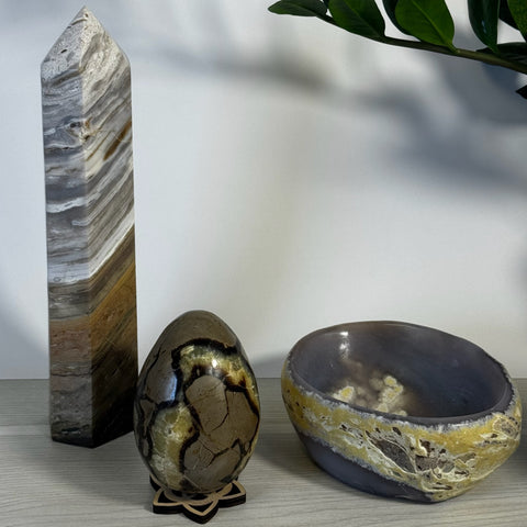 Kenna's Stylized Imperfect Bundle: tall striped crystal tower, brown patterned crystal egg, and a gray and yellow geode bowl.