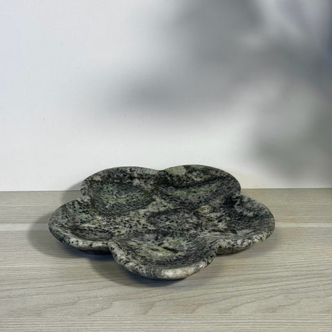 Kiwi fossil flower plate, dark green and black mottled stone, clover-shaped with four shallow sections.