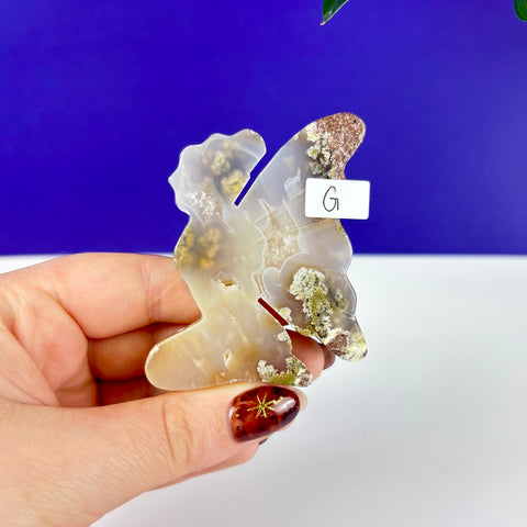 Hand-carved kneeling fairy princess figurine made of translucent scenic moss agate with green mineral inclusions.