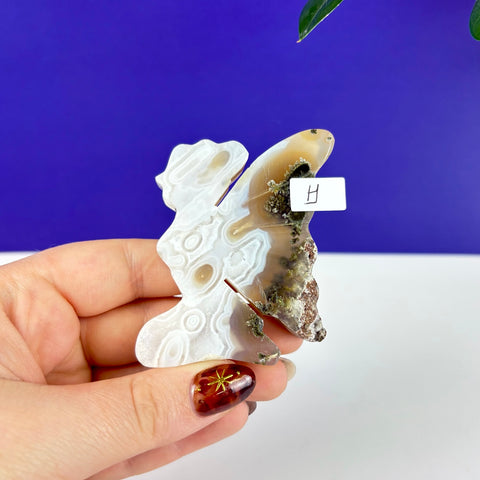 Hand-carved kneeling fairy princess figurine made of scenic moss agate with white banding and natural mineral inclusions.