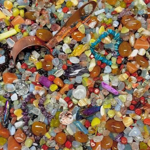 Love Is Love Crystal Confetti with colorful tumbled gemstones, a copper scoop, and a turquoise bracelet.