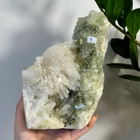 Minty green apophyllite with white scolecite crystal cluster, held in hand.