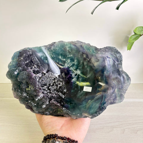 Handheld Mystic Mountain fluorite bowl featuring deep purple and teal crystalline textures with a raw, polished finish.
