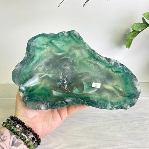 Handheld Mystic Mountain bowl carved from translucent green fluorite with natural crystalline patterns.