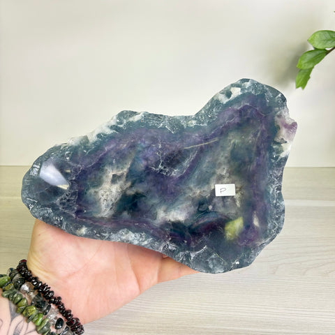 Handheld Mystic Mountain bowl carved from polished fluorite with deep purple, blue, and green mineral inclusions.