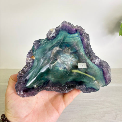 Handheld Mystic Mountain fluorite bowl featuring vibrant purple and teal banded crystal patterns with a polished interior.