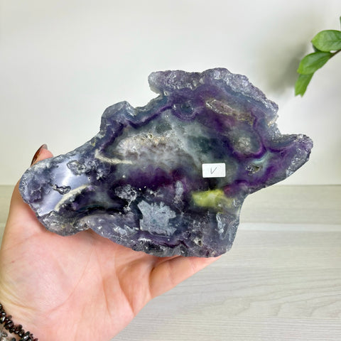 Handheld Mystic Mountain fluorite bowl featuring deep purple, green, and translucent crystalline mineral patterns.