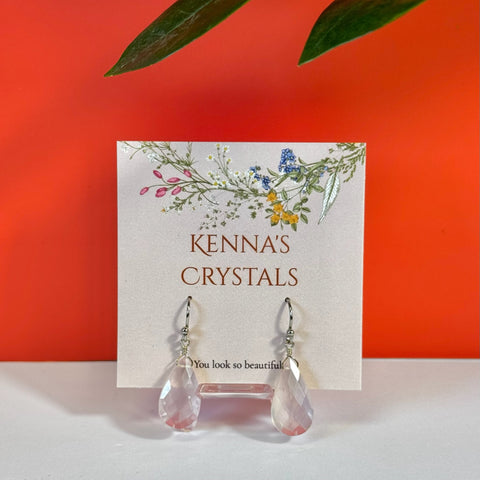 Big teardrop rose quartz earrings with silver hooks on a floral Kenna's Crystals card.