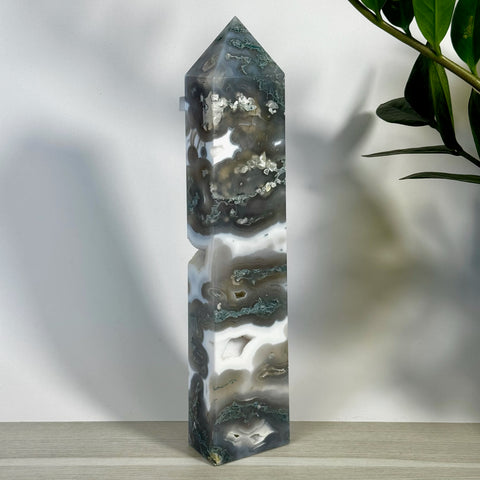 Tall, polished moss agate tower with striking white, gray, and deep green natural patterns.