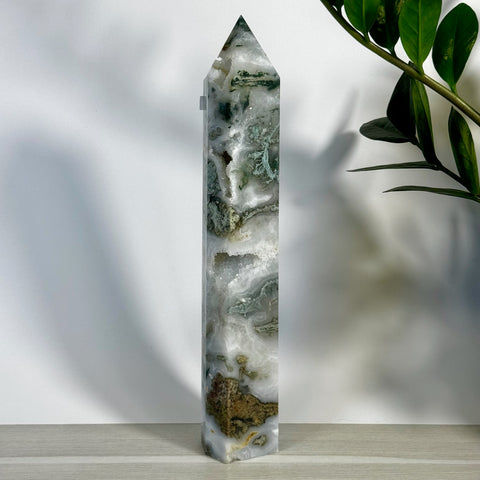 Tall, polished moss agate tower with white, green, and brown natural patterns, pointed top.