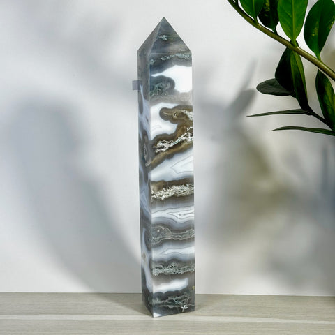 Tall, polished moss agate tower with striking white, gray, and brown swirling patterns.