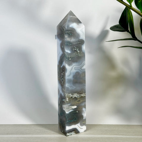 Tall, polished moss agate tower with striking white, grey, and green swirling patterns.