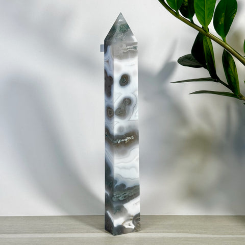 Tall, polished moss agate tower with striking white, grey, and green natural patterns.