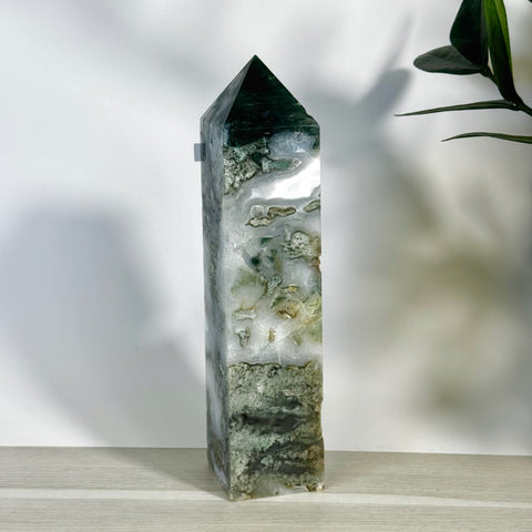 Tall, polished moss agate tower with white, green, and clear natural patterns, featuring a pointed top.