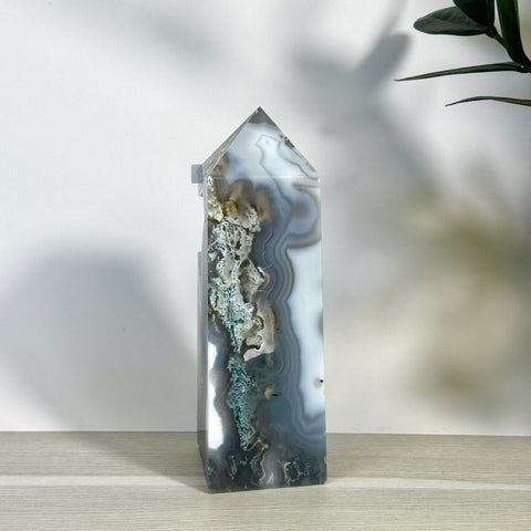 Tall, polished moss agate tower with white, gray, and green natural patterns.
