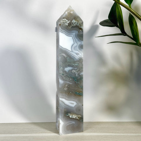 Tall, polished moss agate tower with intricate white, gray, and green swirling patterns.