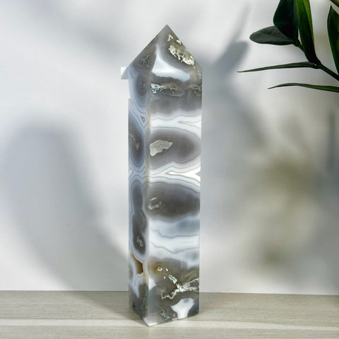 Tall, polished moss agate tower with white, gray, and brown swirling patterns, pointed top.