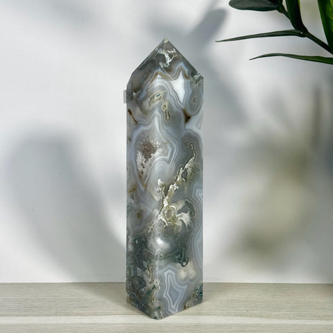 Tall, polished moss agate tower with intricate grey, white, and green swirling patterns.