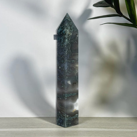 Tall, polished moss agate tower with dark green and white swirling patterns, pointed top.