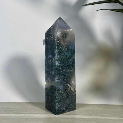 Tall, polished moss agate tower with intricate green, white, and gray patterns, pointed top.