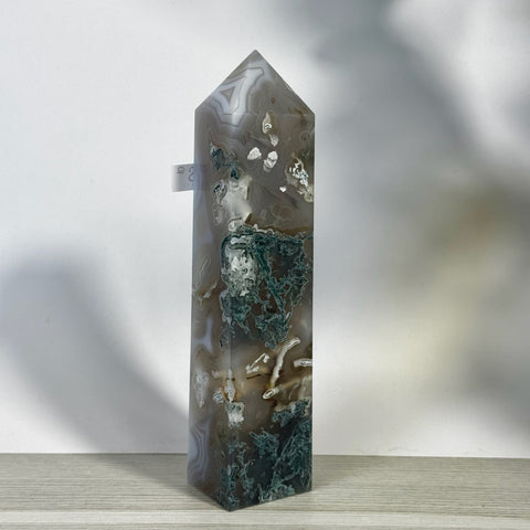 Polished moss agate tower with natural green, white, and brown inclusions, featuring a pointed top.