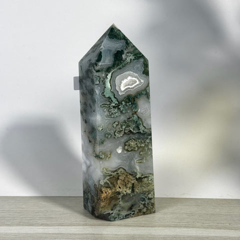 Tall, polished moss agate tower with white, green, and brown natural patterns.
