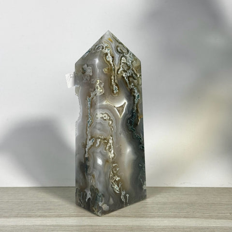 Tall, polished moss agate tower with natural gray, white, and green swirling patterns.