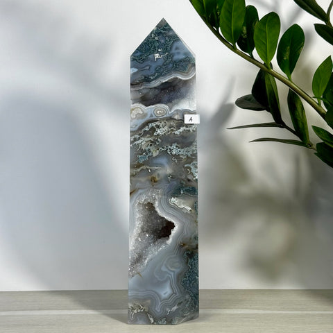 Tall, polished moss agate tower (variant A) with grey, white, and green swirling patterns and a sparkling geode cavity.