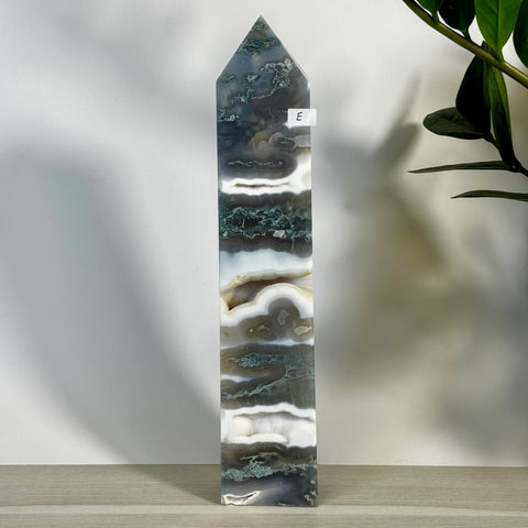 Tall, polished moss agate tower (variant E) with striking green, white, and gray bands, featuring a pointed top.