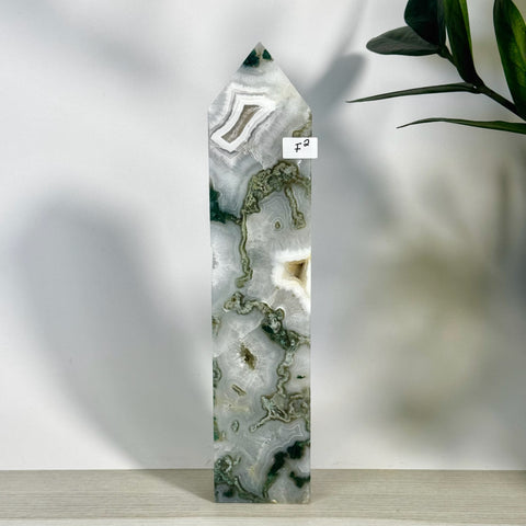 Tall, polished moss agate tower (F2) with intricate green, white, and clear natural patterns.
